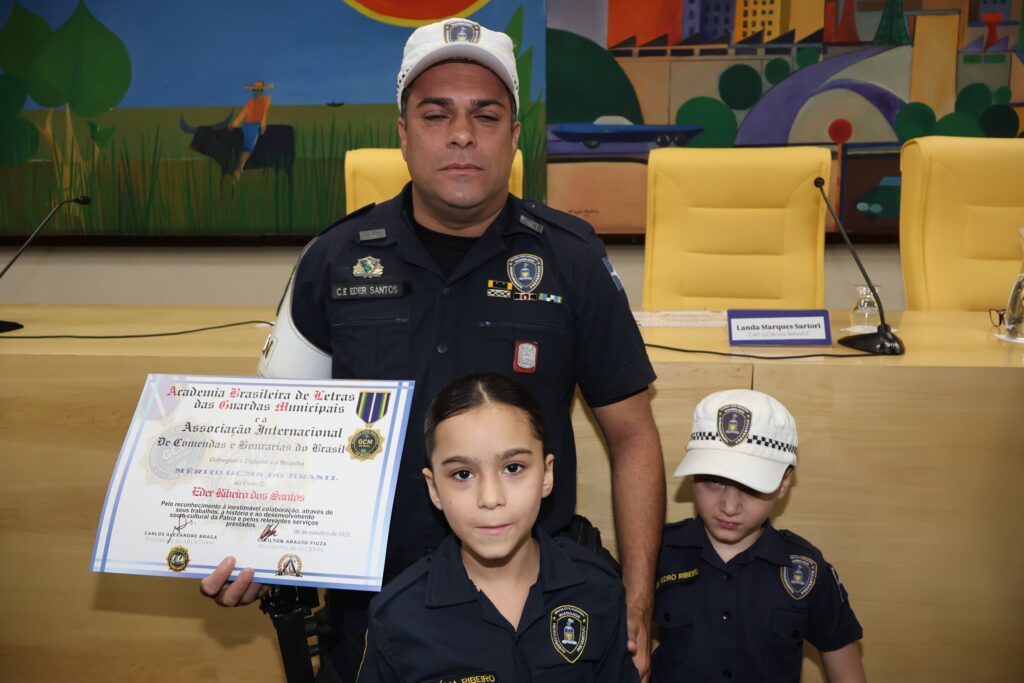 Guarda homenageado com os filhos, vestidos de guardas, após receber a comenda